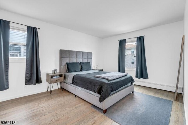1105 Essex Ave Unit 2, Linden City, NJ 07036 - bedroom featuring a baseboard radiator, light wood-style floors, and baseboards
