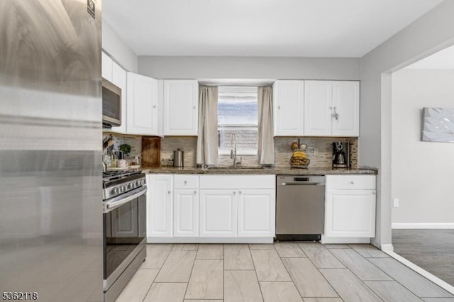 1105 Essex Ave Unit 2, Linden City, NJ 07036 - kitchen featuring stainless steel appliances, dark stone counters, decorative backsplash, a sink, and white cabinets