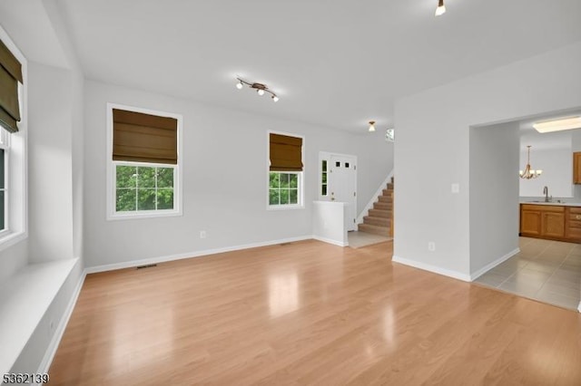231 Swathmore Dr, Nutley Twp, NJ 07110 - empty room with light wood-style flooring, a chandelier, and stairs