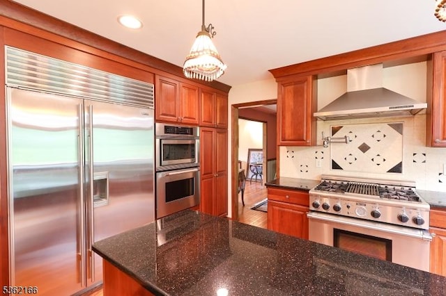 1 Willow Brook Ln, Clinton Twp, NJ 08801 - kitchen featuring premium appliances, wall chimney range hood, decorative backsplash, a chandelier, and brown cabinets