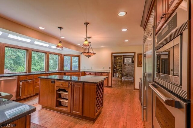 1 Willow Brook Ln, Clinton Twp, NJ 08801 - kitchen featuring brown cabinets, stainless steel appliances, a kitchen island, light wood-style floors, and hanging light fixtures
