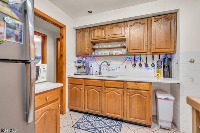 192 Market St, Belvidere Twp, NJ 07823 - kitchen with freestanding refrigerator, a sink, light countertops, white microwave, and brown cabinets