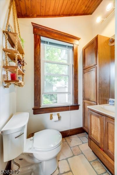 136 Pershing Ave, Nutley Twp, NJ 07110 - bathroom with wood ceiling, toilet, vaulted ceiling, vanity, and stone tile floors