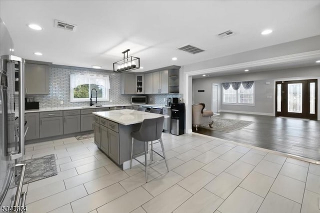 130 Decker Rd, Butler Boro, NJ 07405 - kitchen featuring gray cabinets, open shelves, open floor plan, stainless steel microwave, and a kitchen bar