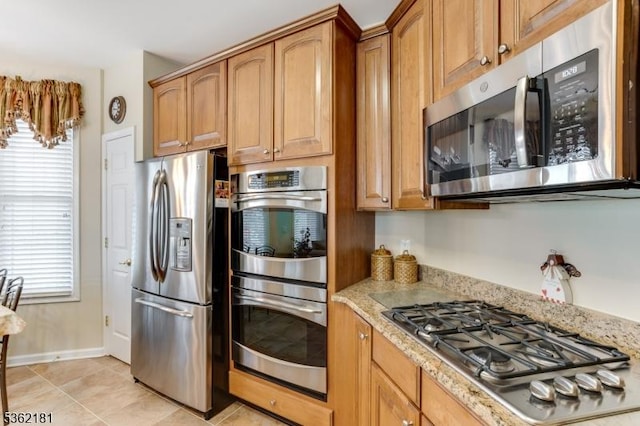 24 Quartz Way, Woodland Park, NJ 07424 - kitchen featuring stainless steel appliances, light stone counters, light tile patterned flooring, baseboards, and brown cabinets