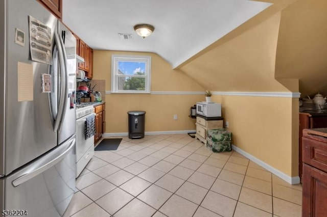 280 Highland Ave Unit 3, Kearny Town, NJ 07032 - kitchen with freestanding refrigerator, white gas range, vaulted ceiling, light tile patterned floors, and under cabinet range hood