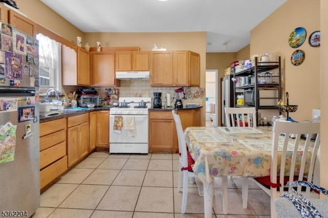 280 Highland Ave Unit 3, Kearny Town, NJ 07032 - kitchen with white gas range oven, freestanding refrigerator, under cabinet range hood, dark countertops, and tasteful backsplash