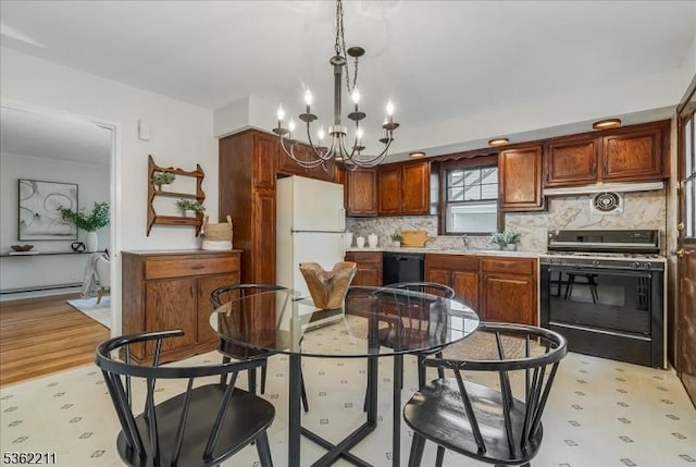248 Knickerbocker Rd, Closter Boro, NJ 07624 - kitchen with gas stove, freestanding refrigerator, a chandelier, a sink, and decorative backsplash