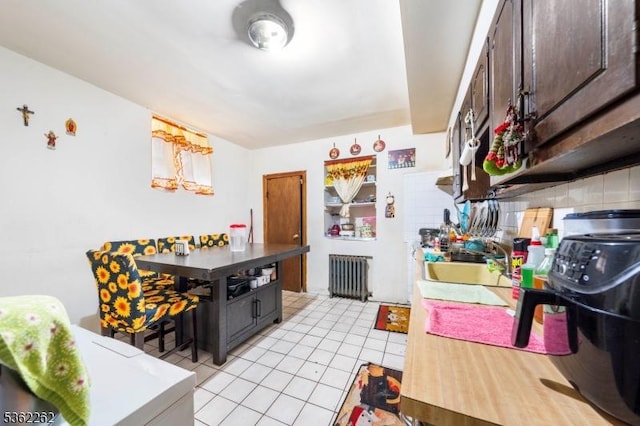 639 N 8th St, Newark City, NJ 07107 - kitchen featuring radiator heating unit, light tile patterned floors, dark brown cabinetry, and a sink
