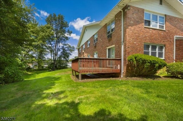 680 State Route 15 Unit 60, Jefferson Twp, NJ 07849 - back of property featuring a deck, a yard, and brick siding