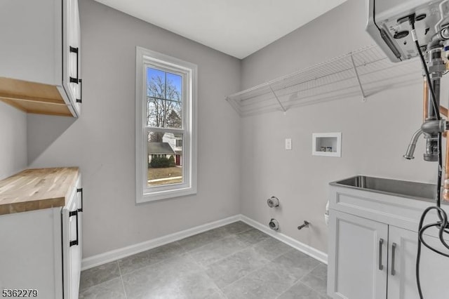 28 Kenmore Rd, Edison Twp, NJ 08817 - laundry room with hookup for a gas dryer, washer hookup, baseboards, light tile patterned flooring, and cabinet space