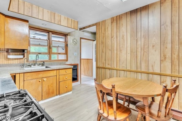 237 Whitmore Ave, Wayne Twp, NJ 07470 - kitchen with a sink, light wood-type flooring, light countertops, wood walls, and range
