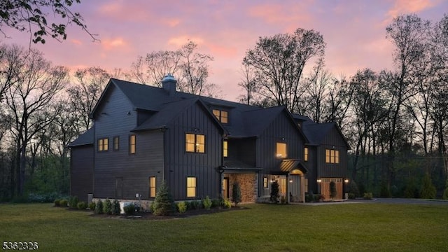 121 Culberson Rd, Bernards Twp, NJ 07920 - back of property at dusk featuring board and batten siding, a lawn, and a chimney