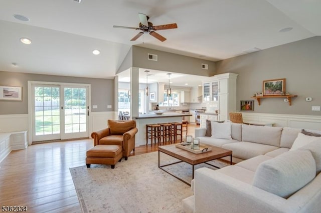 22 Hilltop Cir, Mendham Twp, NJ 07945 - living room with wainscoting, a decorative wall, vaulted ceiling, ceiling fan, and plenty of natural light
