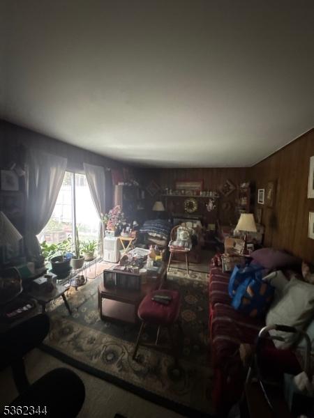 61 N Hillside Ave, Roxbury Twp, NJ 07847 - living room featuring wooden walls and carpet