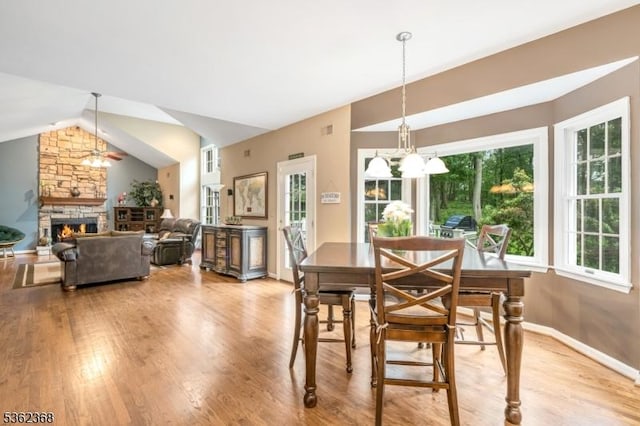 16 Olde York Rd, Randolph Twp, NJ 07869 - dining room with vaulted ceiling, a stone fireplace, a chandelier, and wood finished floors