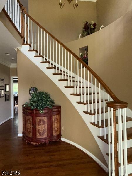 16 Olde York Rd, Randolph Twp, NJ 07869 - staircase with wood finished floors, crown molding, a high ceiling, and a chandelier