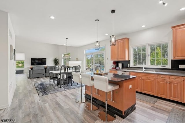 7 Cranberry Ct, North Haledon Boro, NJ 07508 - kitchen with a sink, light wood-style floors, white dishwasher, a kitchen island, and a breakfast bar area