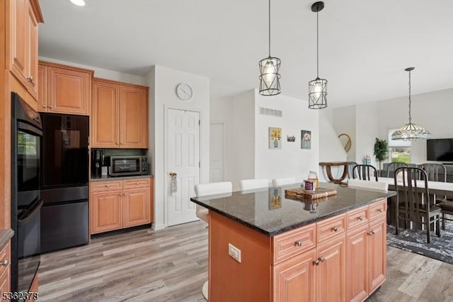 7 Cranberry Ct, North Haledon Boro, NJ 07508 - kitchen with light wood-type flooring, refrigerator, a kitchen island, pendant lighting, and dark stone countertops