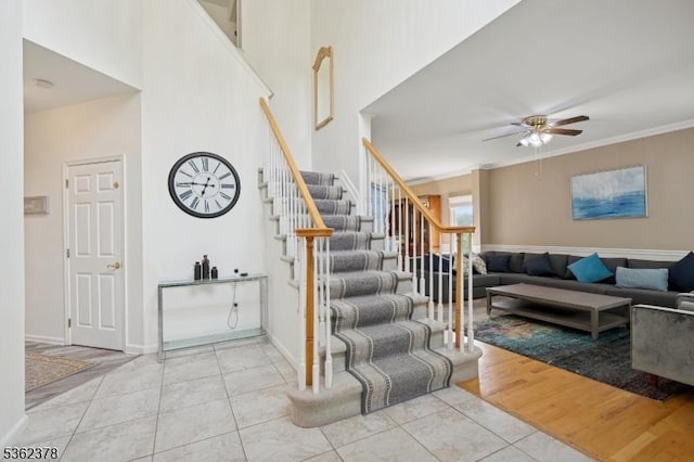 7 Cranberry Ct, North Haledon Boro, NJ 07508 - staircase featuring tile patterned flooring, a ceiling fan, a towering ceiling, baseboards, and crown molding