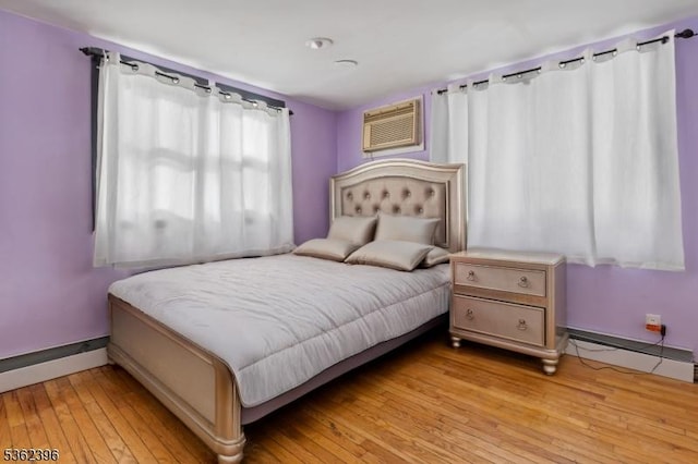 23 Foundry St, Newark City, NJ 07105 - bedroom with a baseboard heating unit, light wood-style flooring, a wall unit AC, and baseboards