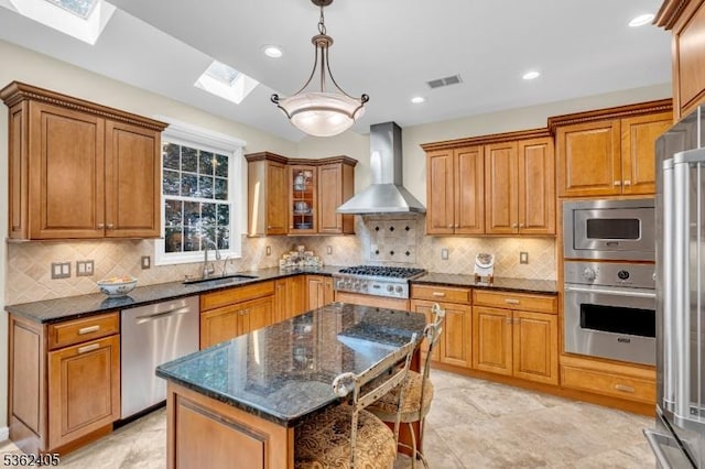 61 Bradley Ln, Bridgewater Twp, NJ 08807 - kitchen with stainless steel appliances, wall chimney range hood, a skylight, brown cabinetry, and dark stone countertops