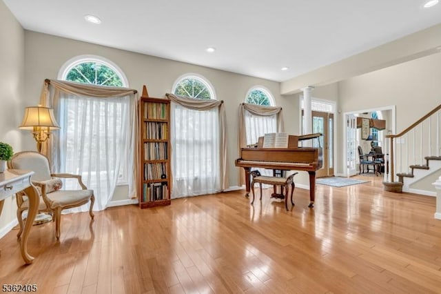 61 Bradley Ln, Bridgewater Twp, NJ 08807 - living area with ornate columns, stairs, light wood finished floors, and recessed lighting