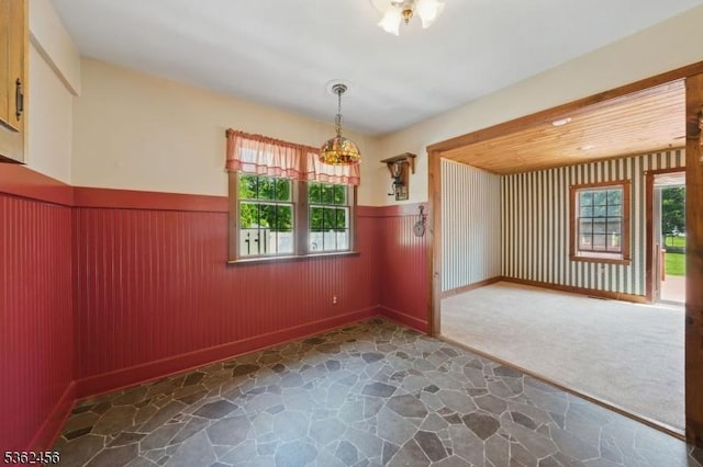 7 Claudia Rd, Hillsborough Twp, NJ 08844 - unfurnished dining area with wainscoting, stone floors, baseboards, and a chandelier