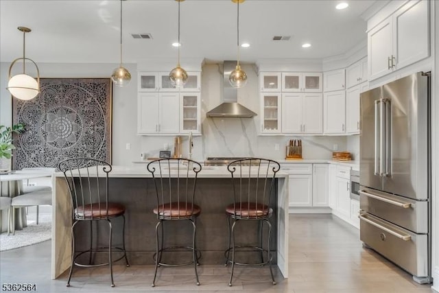 302 Tiffany Way Unit 302, Watchung Boro, NJ 07069 - kitchen featuring high quality fridge, wall chimney exhaust hood, white cabinets, a breakfast bar area, and pendant lighting