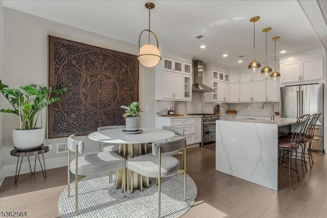 302 Tiffany Way Unit 302, Watchung Boro, NJ 07069 - kitchen with high quality appliances, wall chimney range hood, light wood-style flooring, white cabinetry, and glass insert cabinets