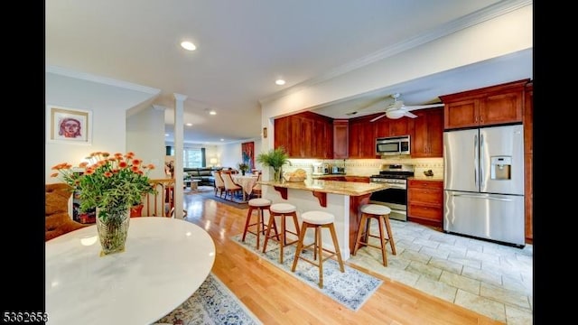 8 Clark Ct, Bernards Twp, NJ 07920 - kitchen with stainless steel appliances, ornamental molding, a breakfast bar, tasteful backsplash, and a peninsula