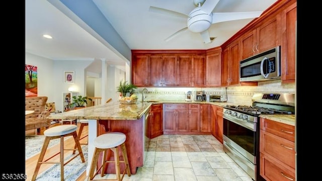 8 Clark Ct, Bernards Twp, NJ 07920 - kitchen featuring appliances with stainless steel finishes, a breakfast bar area, a peninsula, tasteful backsplash, and a ceiling fan