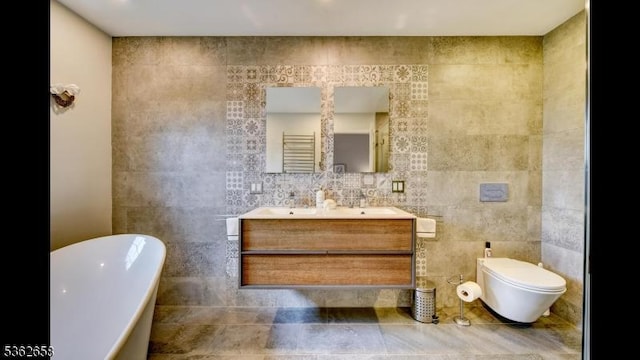 8 Clark Ct, Bernards Twp, NJ 07920 - full bathroom featuring tile walls, a freestanding tub, double vanity, and a towel warmer