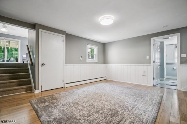 22 Corwin St, Randolph Twp, NJ 07869 - unfurnished room with a baseboard heating unit, wainscoting, healthy amount of natural light, stairway, and wood finished floors