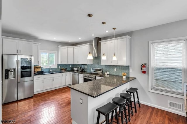 146 Williamson Ave, Hillside Twp, NJ 07205 - kitchen with appliances with stainless steel finishes, wall chimney exhaust hood, a sink, a peninsula, and decorative backsplash