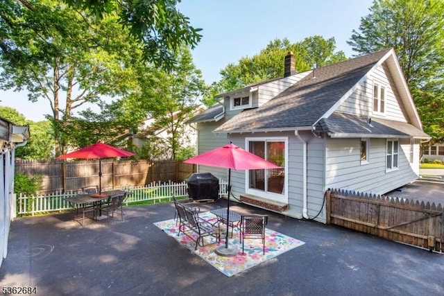44 Lincoln Ave, Livingston Twp, NJ 07039 - back of house with outdoor dining area, a patio, a chimney, a fenced backyard, and a shingled roof
