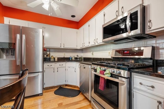 6 Pelican Pt, Hampton Twp, NJ 07860 - kitchen with appliances with stainless steel finishes, dark countertops, light wood-style flooring, and tasteful backsplash