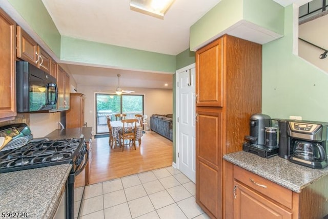 17 Barnida Dr, East Hanover Twp, NJ 07936 - kitchen featuring black microwave, gas stove, a ceiling fan, light tile patterned floors, and brown cabinets