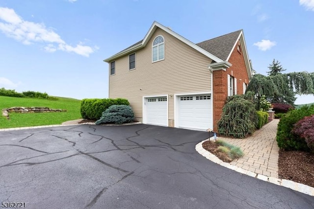 2 Skyview Dr, Sparta Twp, NJ 07871 - view of side of home featuring asphalt driveway, an attached garage, brick siding, and a lawn