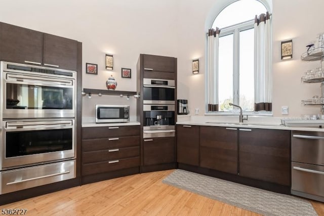27 Mare Haven Ct, North Brunswick Twp, NJ 08902 - kitchen featuring stainless steel appliances, a warming drawer, dark brown cabinets, light countertops, and light wood finished floors