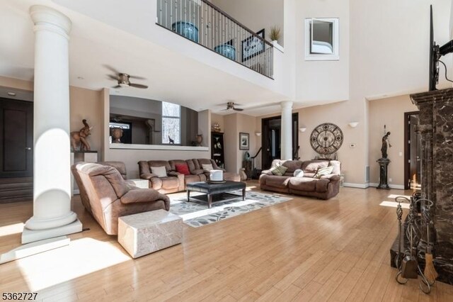 27 Mare Haven Ct, North Brunswick Twp, NJ 08902 - living room with ornate columns, a ceiling fan, wood finished floors, a high ceiling, and baseboards