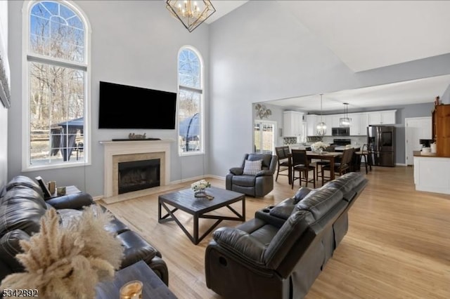 522 Stanhope Rd, Byram Twp, NJ 07871 - living room featuring high vaulted ceiling, light wood finished floors, a fireplace with flush hearth, and a chandelier