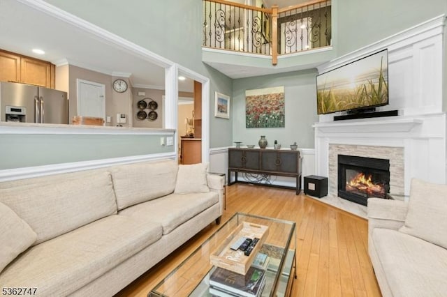 3607 Park Pl, Springfield Twp, NJ 07081 - living room with a stone fireplace, light wood-type flooring, a high ceiling, ornamental molding, and recessed lighting
