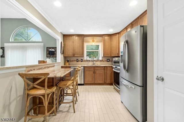 3607 Park Pl, Springfield Twp, NJ 07081 - kitchen featuring stainless steel appliances, brown cabinets, plenty of natural light, a kitchen bar, and recessed lighting