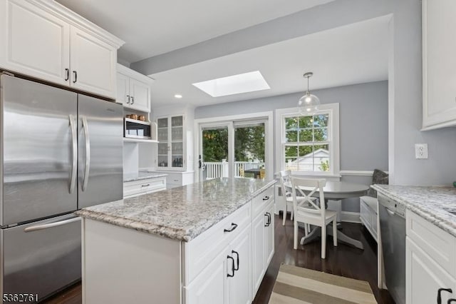 30 Hillcrest Ter, Verona Twp, NJ 07044 - kitchen with stainless steel appliances, a skylight, white cabinets, dark wood-type flooring, and light stone counters