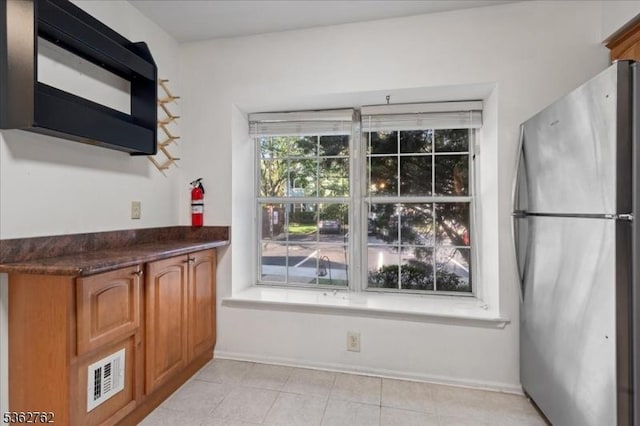 450 Saint Giles Ct, Franklin Twp, NJ 08873 - kitchen with freestanding refrigerator, dark countertops, brown cabinets, light tile patterned floors, and baseboards