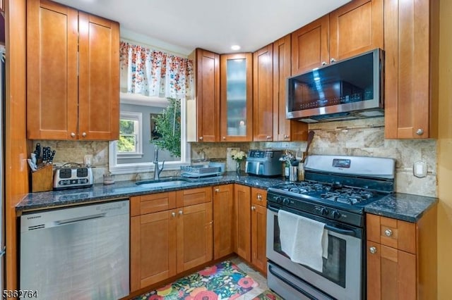 128 Parkside Rd, Plainfield City, NJ 07060 - kitchen with appliances with stainless steel finishes, dark stone countertops, decorative backsplash, brown cabinets, and recessed lighting