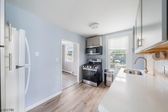 90 Thomas St, Bloomfield Twp, NJ 07003 - kitchen with appliances with stainless steel finishes, a baseboard radiator, healthy amount of natural light, and light countertops