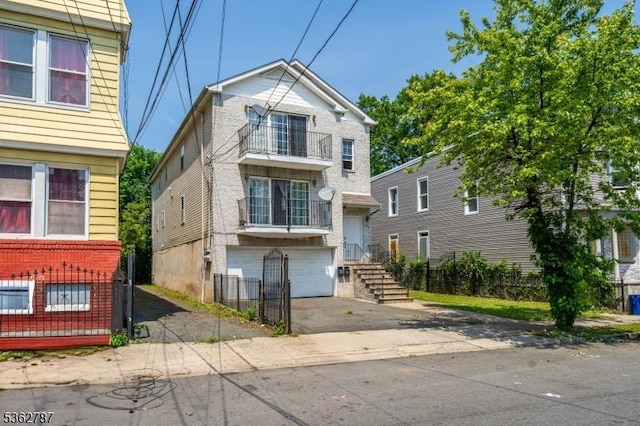 303-305 W Runyon St, Newark City, NJ 07108 - view of front facade featuring a balcony, driveway, and an attached garage