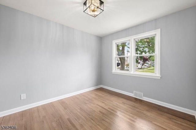 501 E 2nd Ave, Roselle Boro, NJ 07203 - empty room with baseboards, wood finished floors, and a chandelier